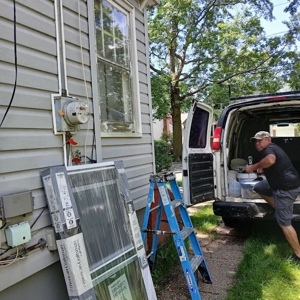 Crew unloading new windows from a work van at a job site