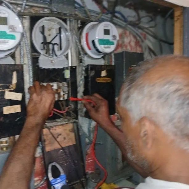 Electrician working inside an electrical service panel